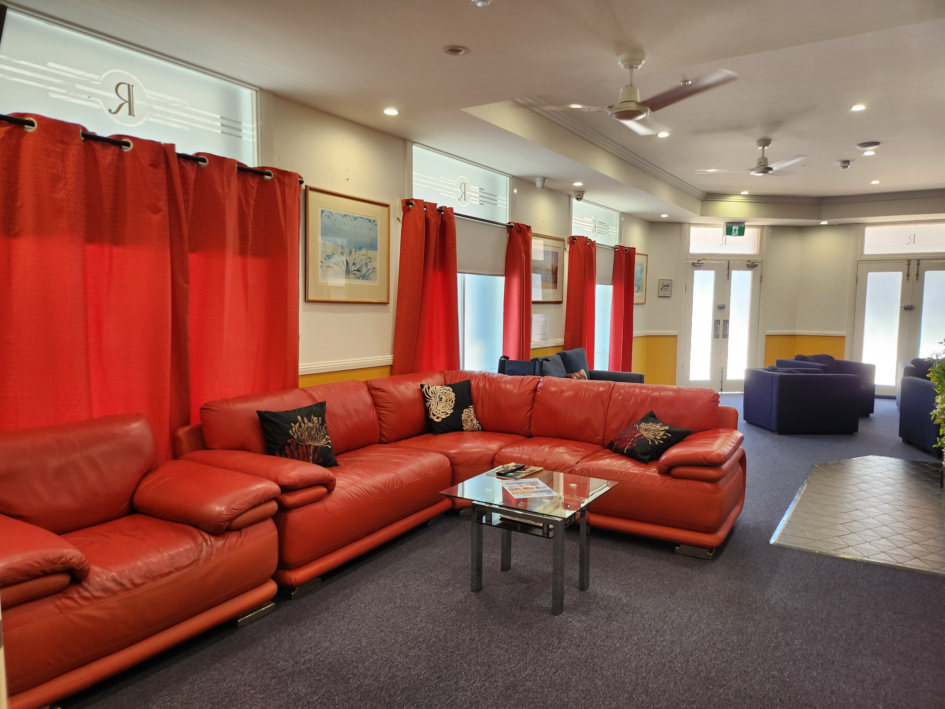 Spacious guest lounge with red leather sofas